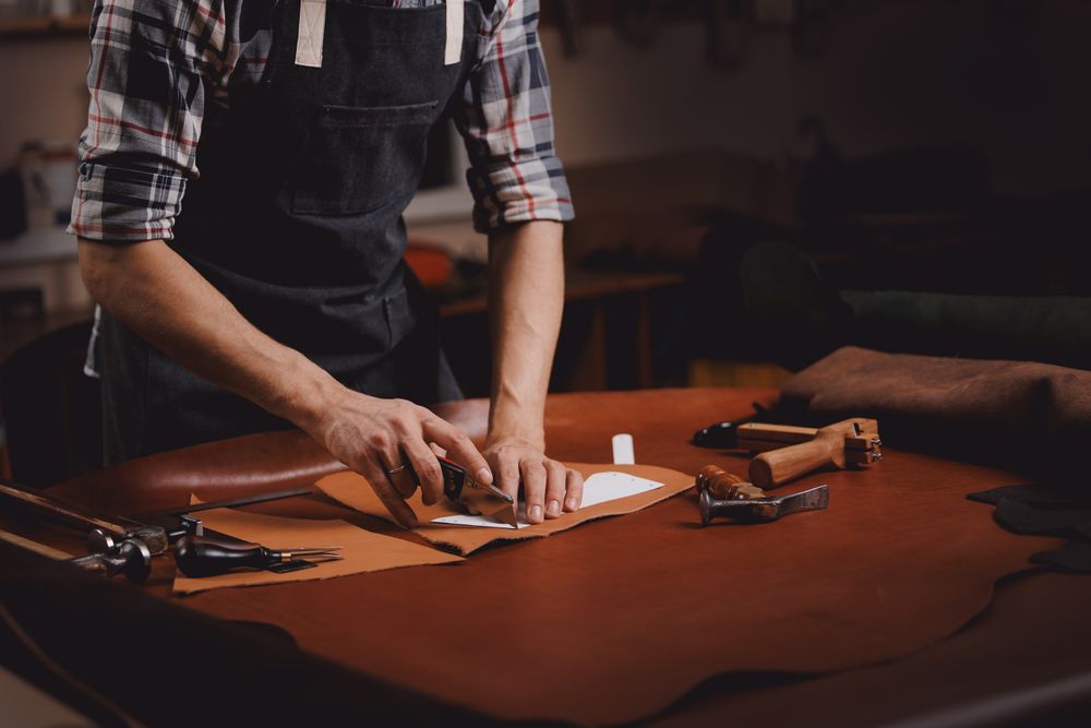 Jasperosso shoemaker cutting a men’s luxury sneakers pattern.