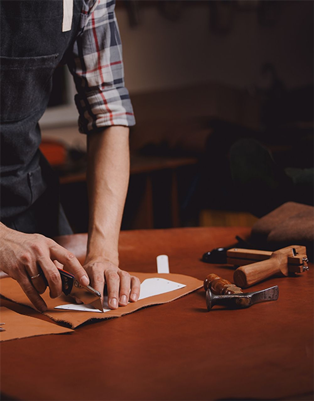 A Jasperosso shoemaker cutting a men’s designer sneakers pattern.