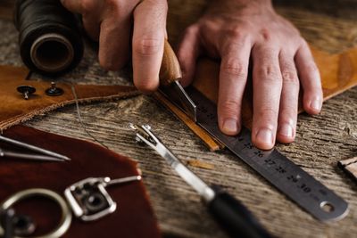 Jasperosso shoemaker measuring and cutting calf leather for luxury men’s sneakers.