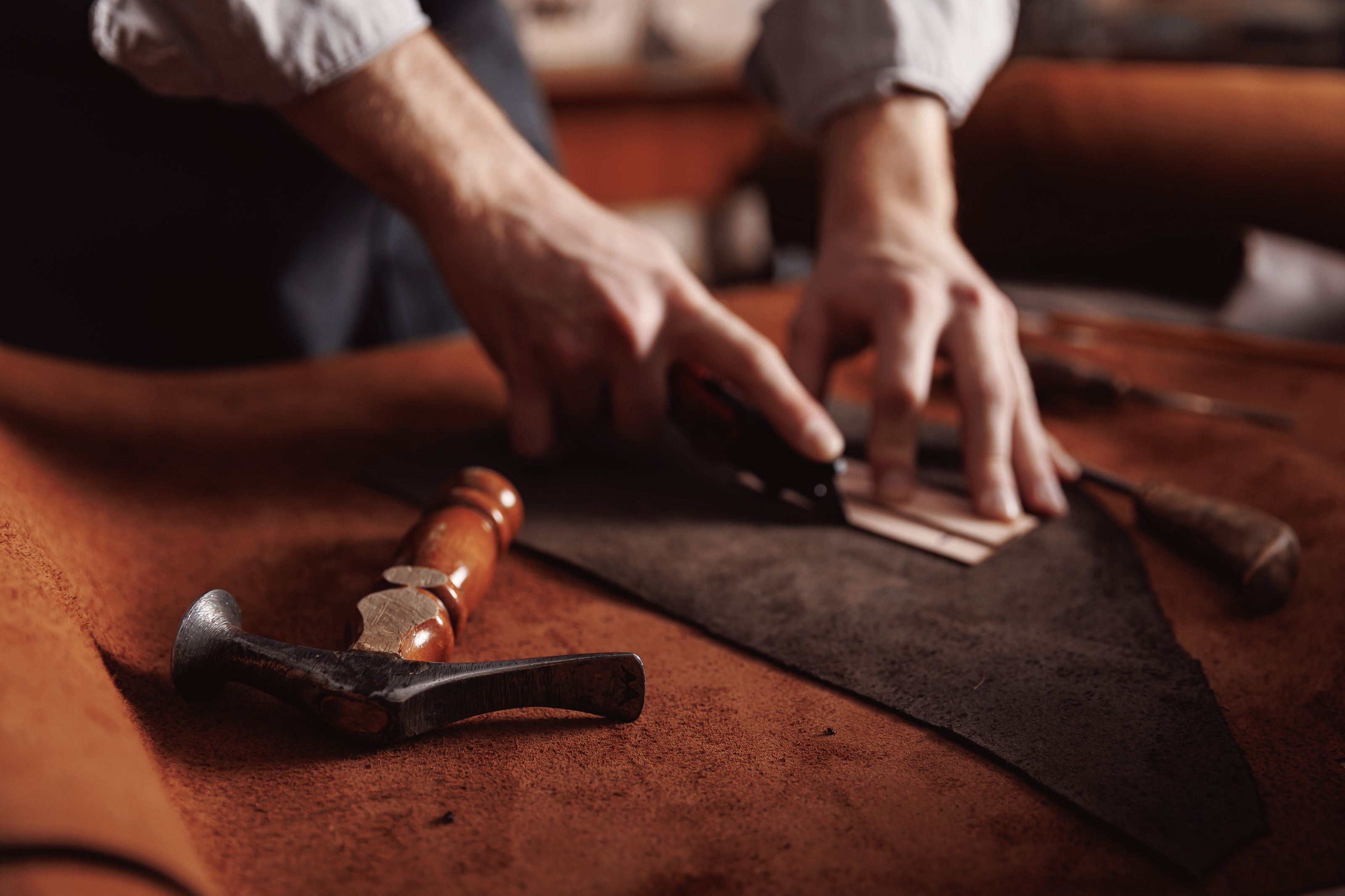Jasperosso shoemaker cutting calf leather, redefining men’s luxury sneakers.